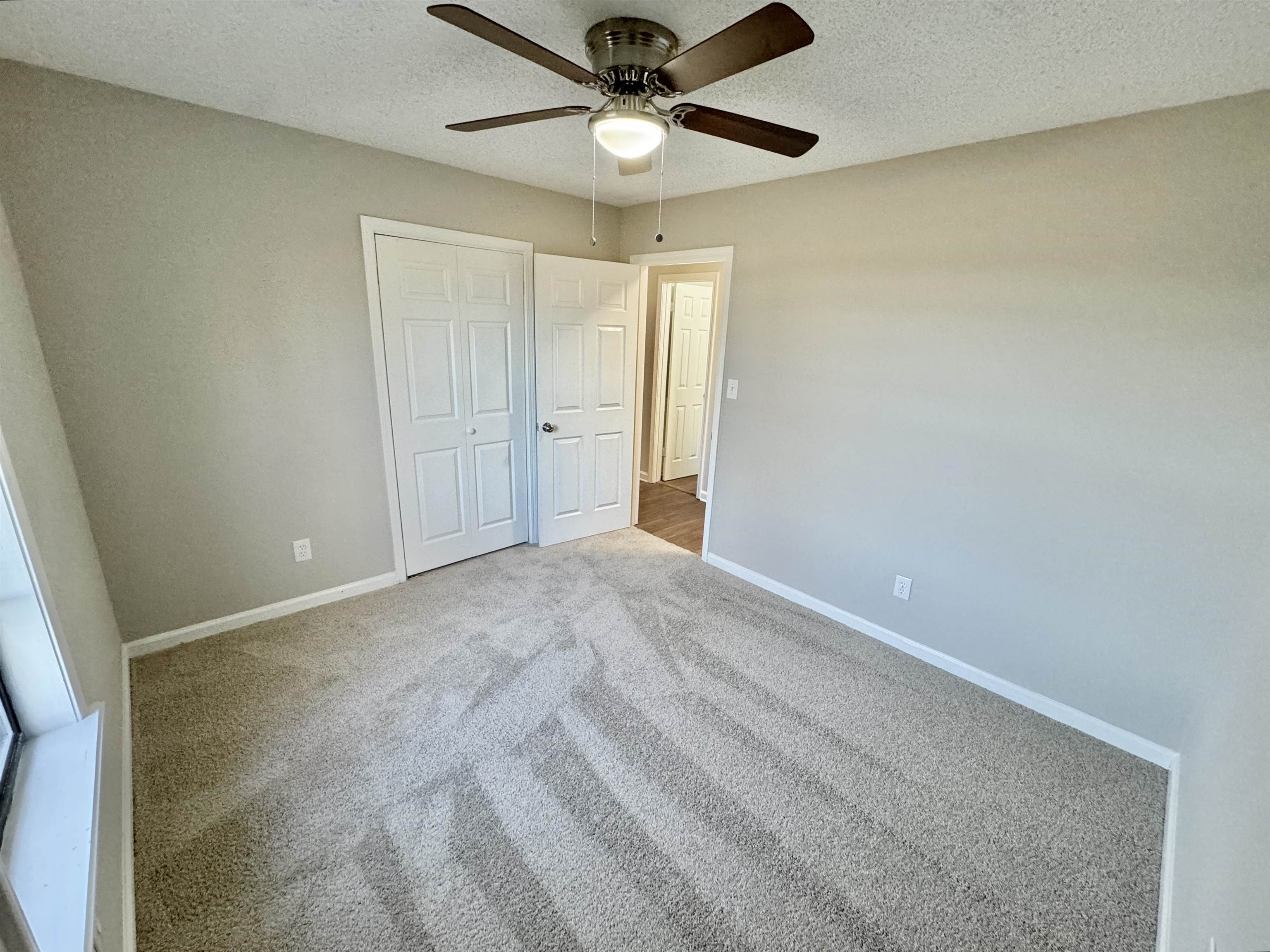 775 Portersville Road Atoka, TN 38004 - Photo 23 of 37 Unfurnished bedroom with a closet, ceiling fan, carpet floors, and a textured ceiling