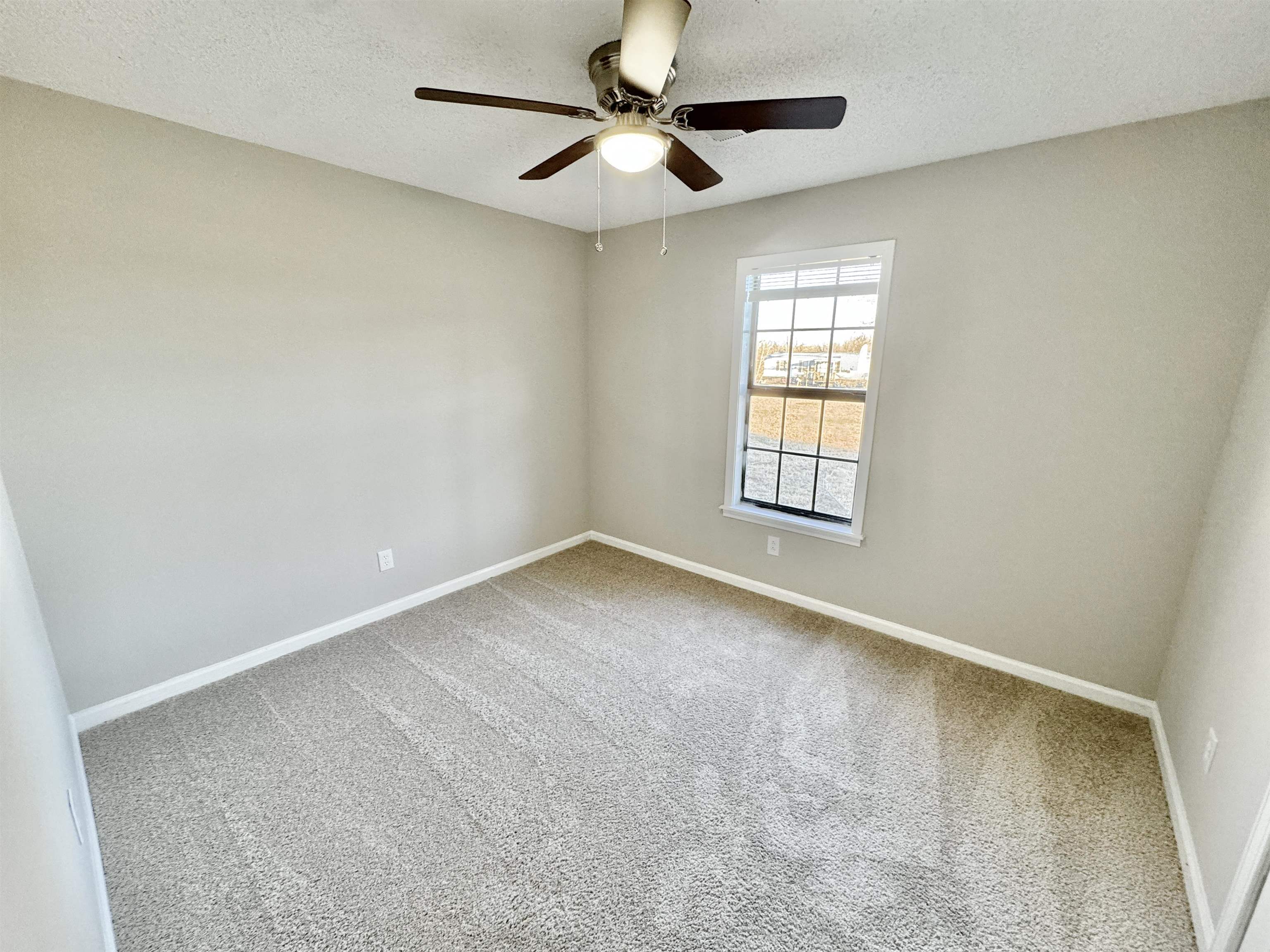 775 Portersville Road Atoka, TN 38004 - Photo 27 of 37 Carpeted spare room featuring ceiling fan and a textured ceiling