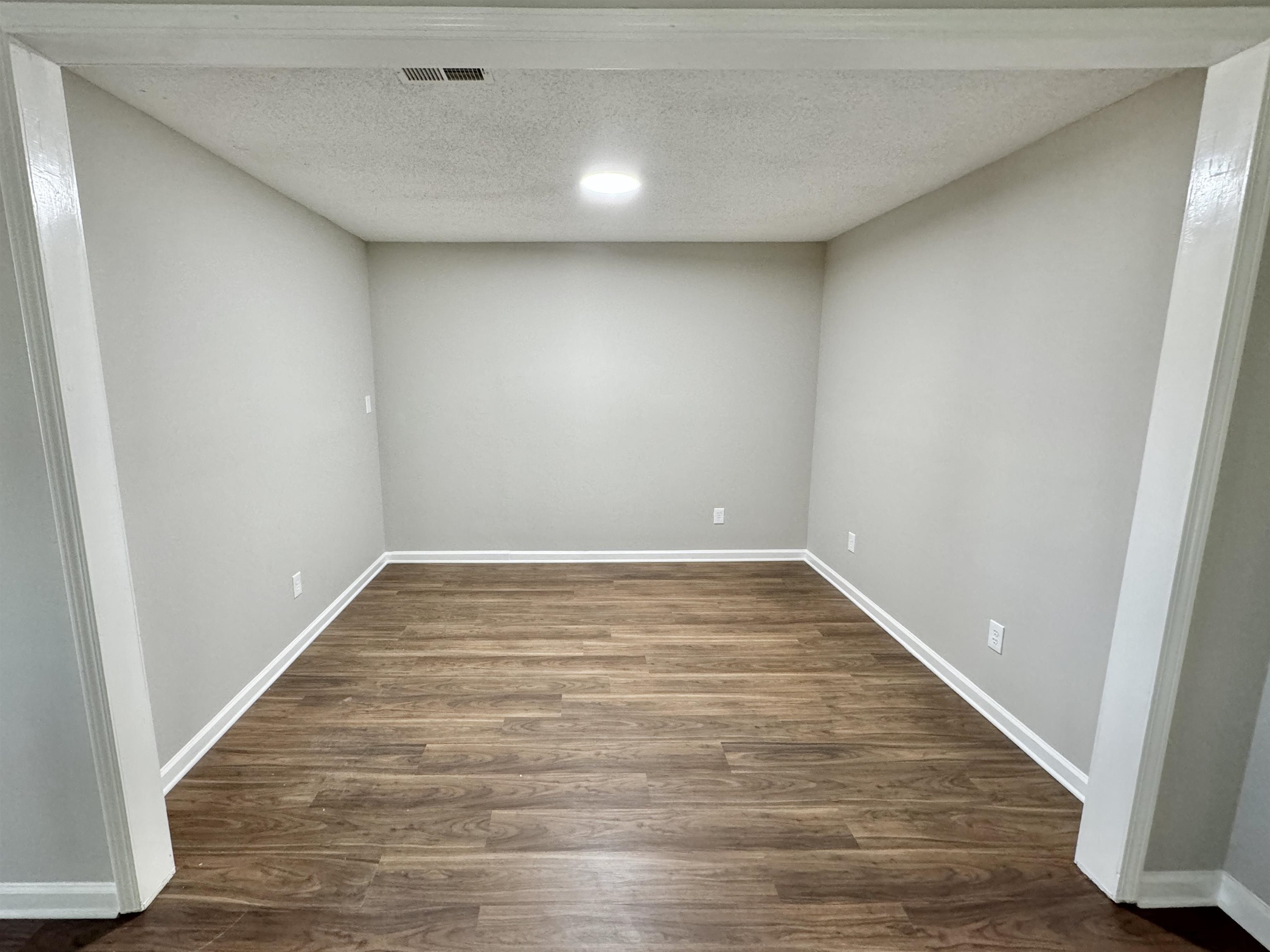 775 Portersville Road Atoka, TN 38004 - Photo 8 of 37 Empty room featuring dark wood-type flooring and a textured ceiling