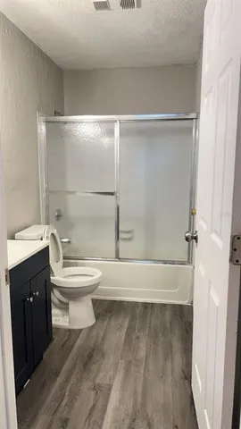 a bathroom with a toilet sink vanity granite and mirror