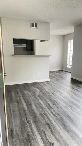 a kitchen with stainless steel appliances a white counter top and wooden floors