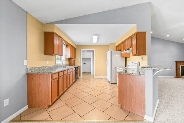 a kitchen with stainless steel appliances granite countertop a refrigerator and a stove