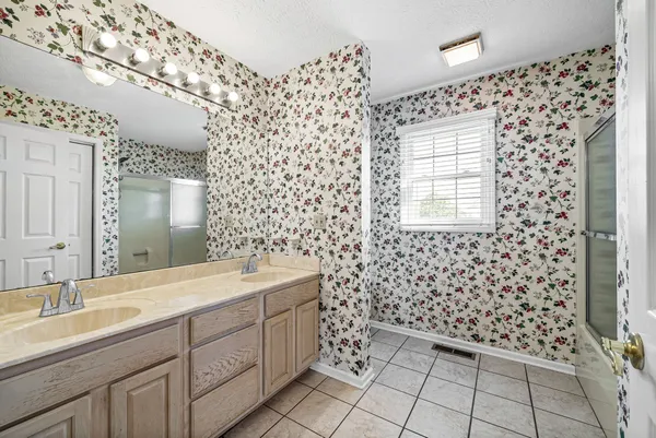 a spacious bathroom with a sink a toilet a mirror and shower