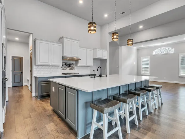 a kitchen with cabinets a sink dishwasher a stove and a refrigerator with wooden floor