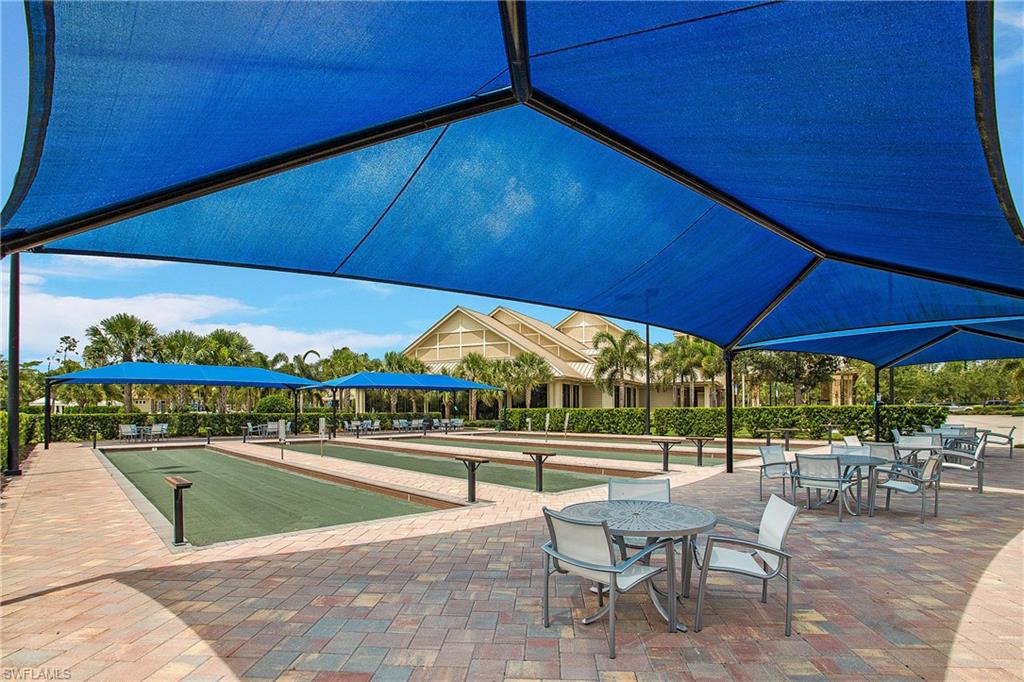 7674 Jacaranda Lane Naples, FL 34114 - Photo 33 of 45 a view of a swimming pool with a chair and tables