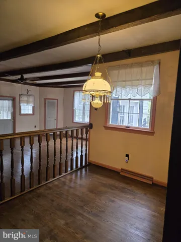 a view of a livingroom with wooden floor and stairs