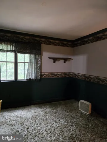 a view of empty room with wooden floor and fireplace