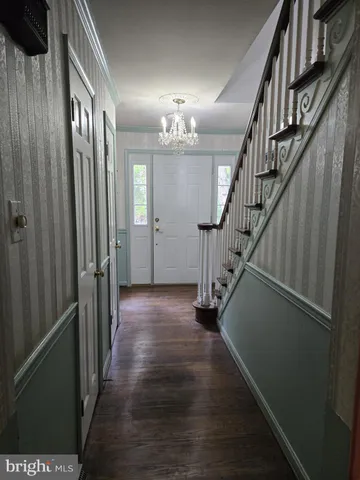 a view of a hallway with stairs and wooden floor