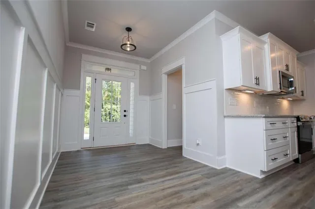 a view of a kitchen with wooden floor and windows