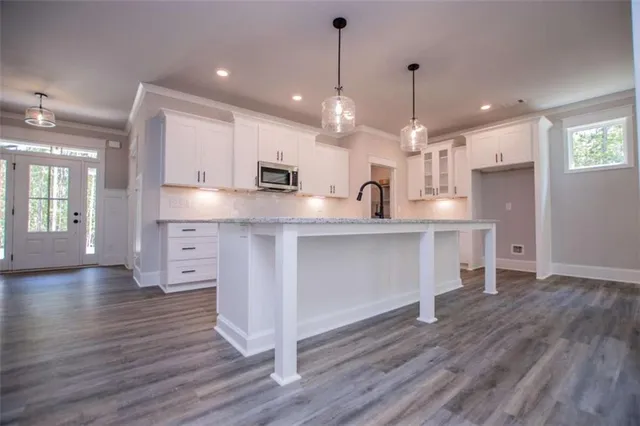 a kitchen with stainless steel appliances granite countertop a sink a stove and a wooden floors