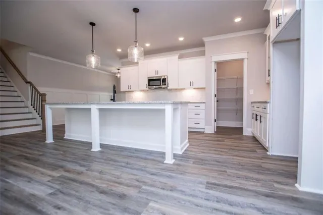 an empty room with wooden floor fireplace and windows