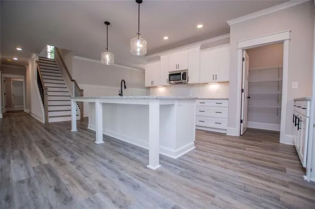 an empty room with wooden floor a fireplace a ceiling fan and windows