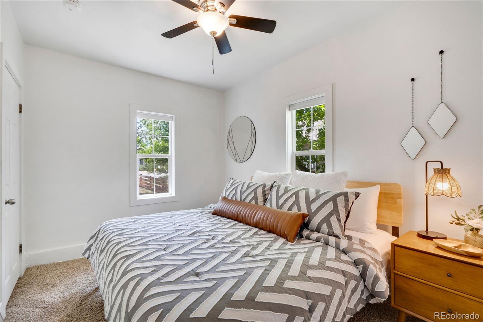 26 Main Street Windsor, CO 80550 - Photo 5 of 14 a bedroom with a bed and a chandelier