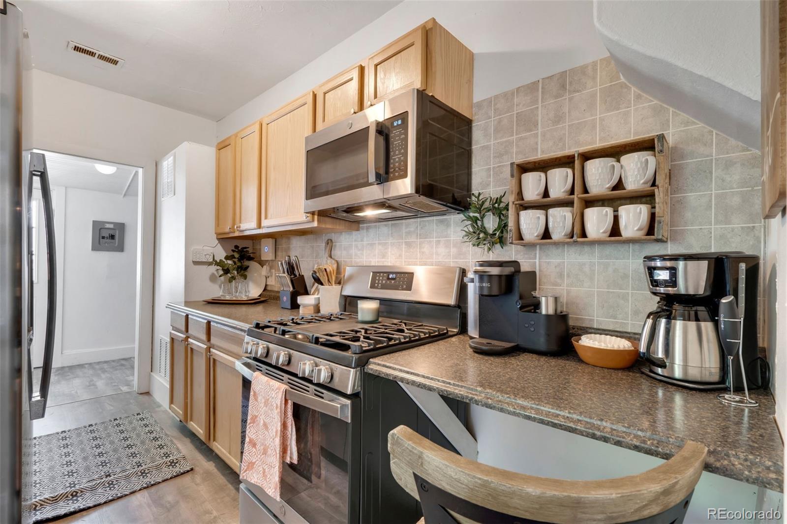 26 Main Street Windsor, CO 80550 - Photo 8 of 14 a kitchen with stainless steel appliances granite countertop a stove and a microwave