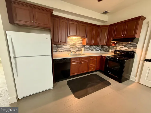 a kitchen with stainless steel appliances granite countertop a refrigerator stove a sink and a refrigerator