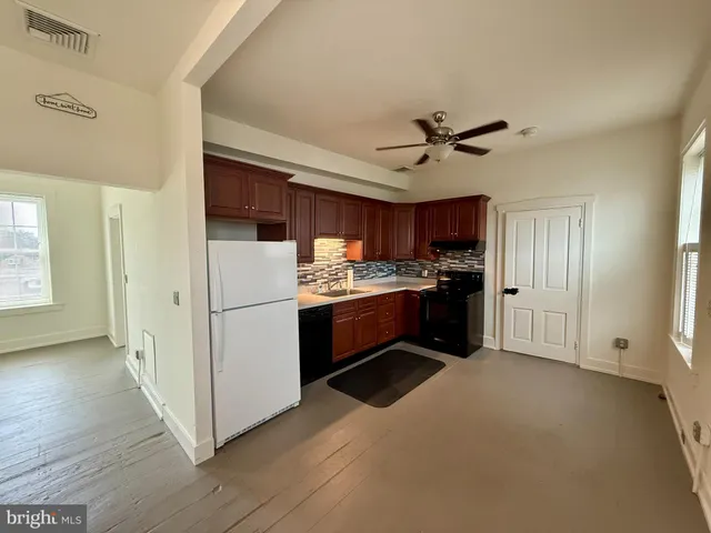 a kitchen with stainless steel appliances a refrigerator a sink a stove a microwave oven with white cabinets