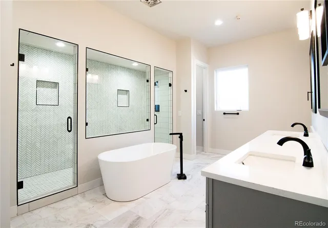 a bathroom with a double vanity sink mirror and bathtub