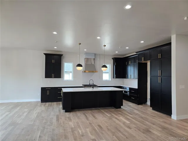a large kitchen with stainless steel appliances a sink and a refrigerator