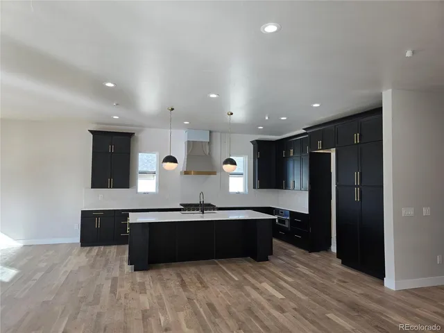 a large kitchen with stainless steel appliances a sink and cabinets