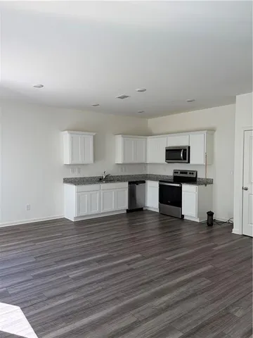 a view of kitchen with wooden floor and electronic appliances