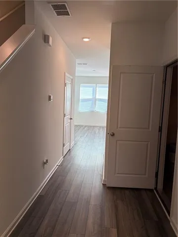a view of a hallway with wooden floor