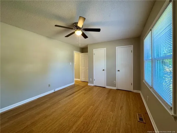 a view of room with wooden floor and ceiling fan