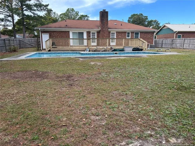 a front view of house with yard space and swimming pool