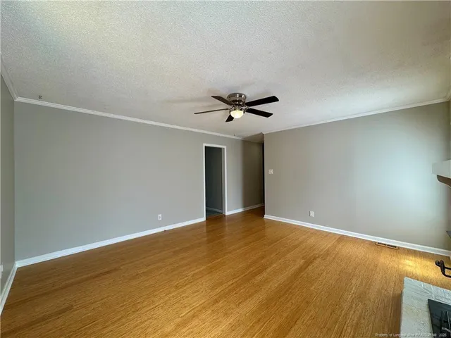a view of an empty room with wooden floor