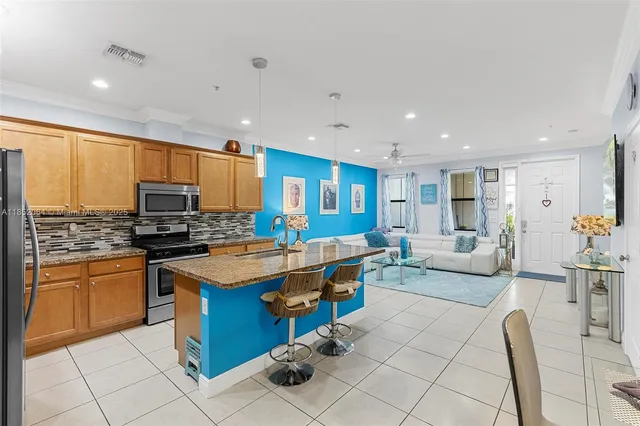 a large kitchen with stainless steel appliances lots of counter space and furniture