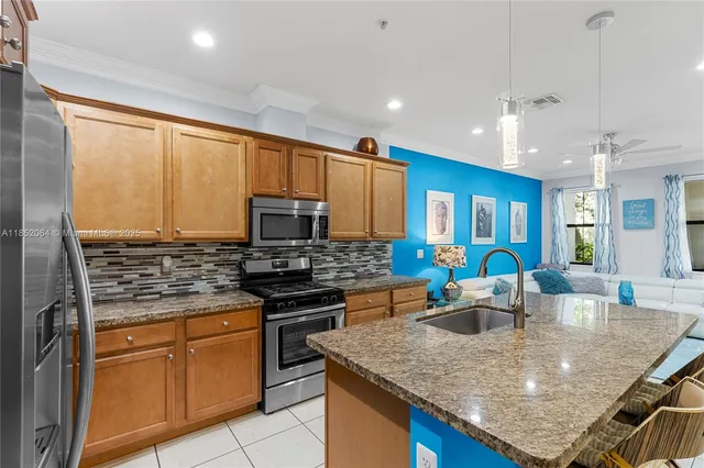 a kitchen with stainless steel appliances granite countertop a refrigerator and a stove top oven