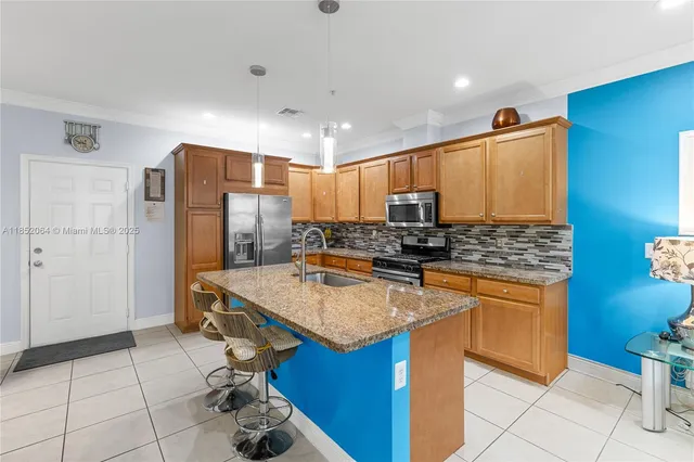 a kitchen with stainless steel appliances granite countertop a sink and a refrigerator