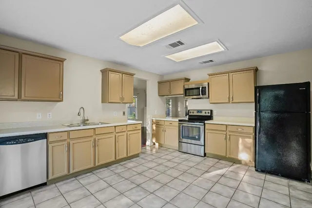 a kitchen with a sink stainless steel appliances and cabinets