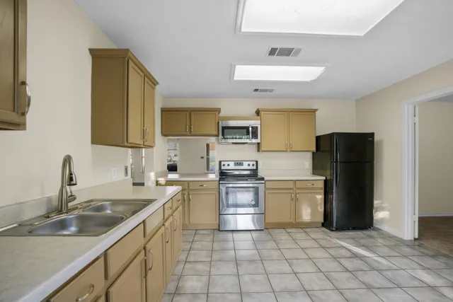 a kitchen with a sink a refrigerator and cabinets