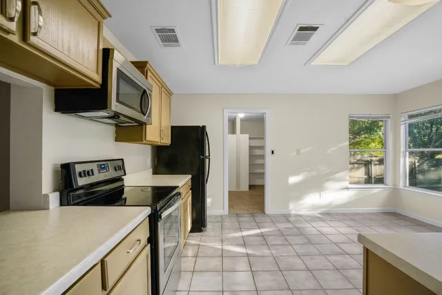 a kitchen with stainless steel appliances a stove refrigerator sink and cabinets