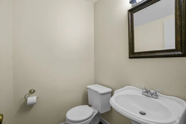 a bathroom with a toilet sink and mirror