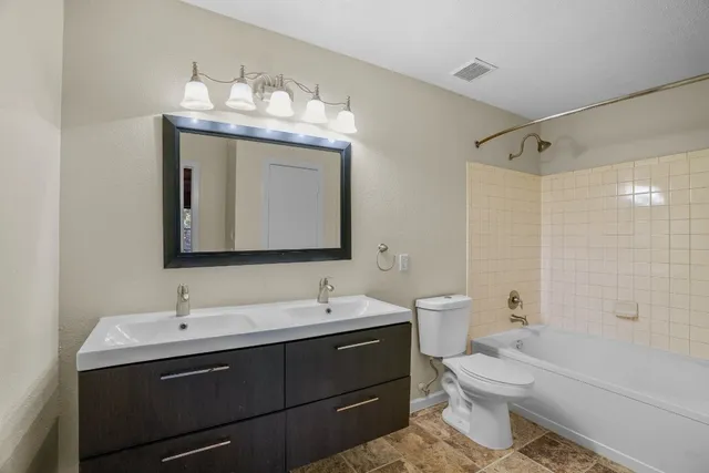 a bathroom with a double vanity sink mirror and toilet