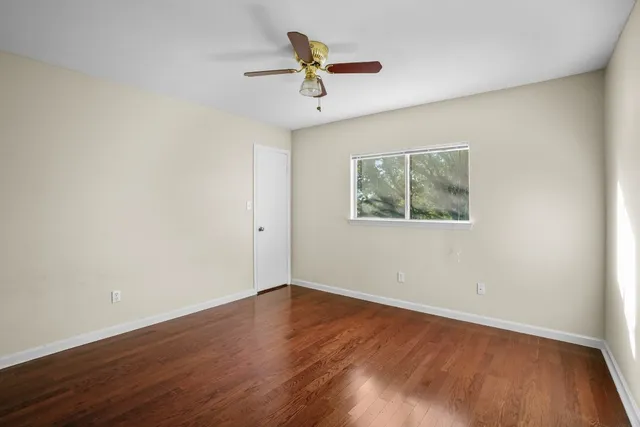 a view of a room with wooden floor and a ceiling fan
