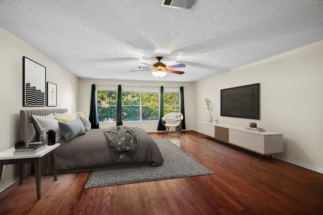 a living room with furniture flat screen tv and a large window