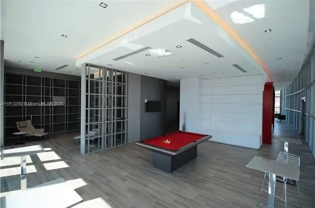 a room with pool table and windows