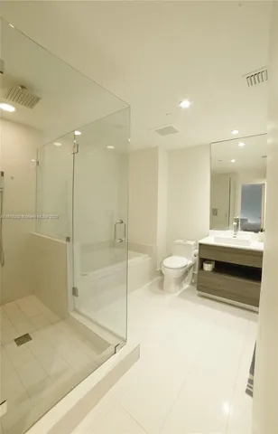 a bathroom with a double vanity sink toilet and shower