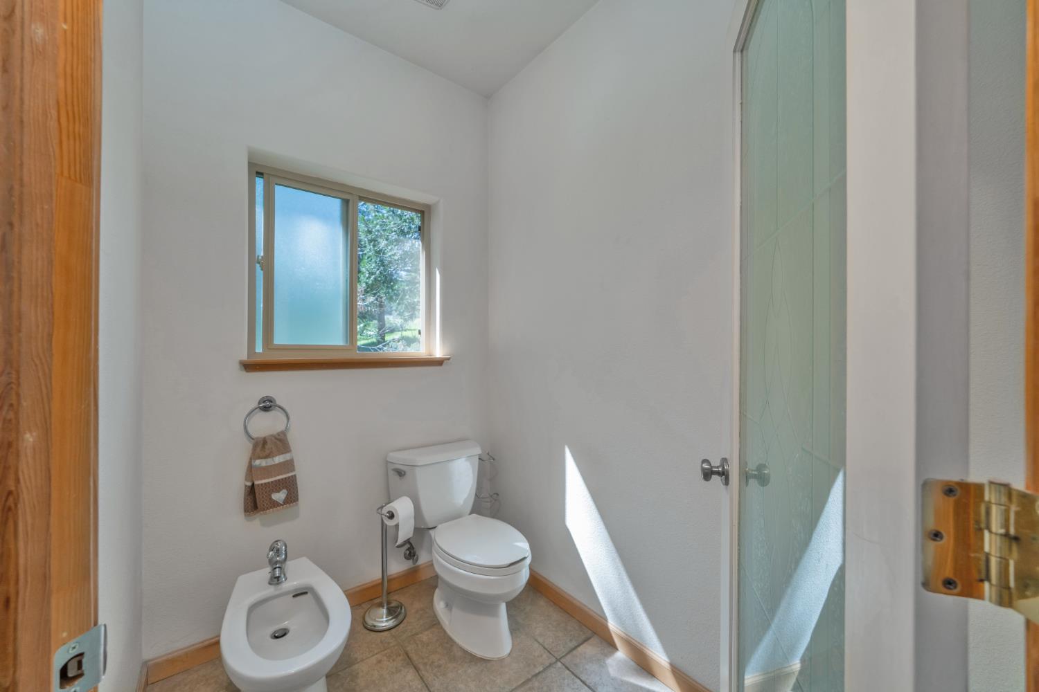 4117 Pearl Road Pollock Pines, CA 95726 - Photo 29 of 47 a white toilet sitting next to a bathroom sink and vanity