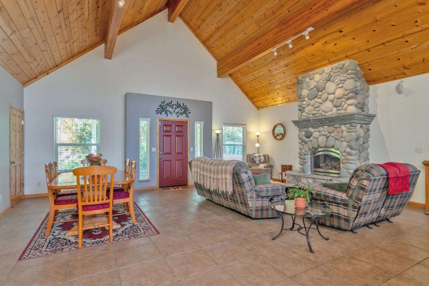 4117 Pearl Road Pollock Pines, CA 95726 - Photo 9 of 47 a living room with furniture a fireplace and a floor to ceiling window