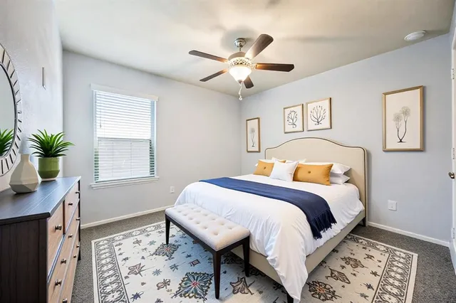 a spacious bedroom with a bed and a chandelier