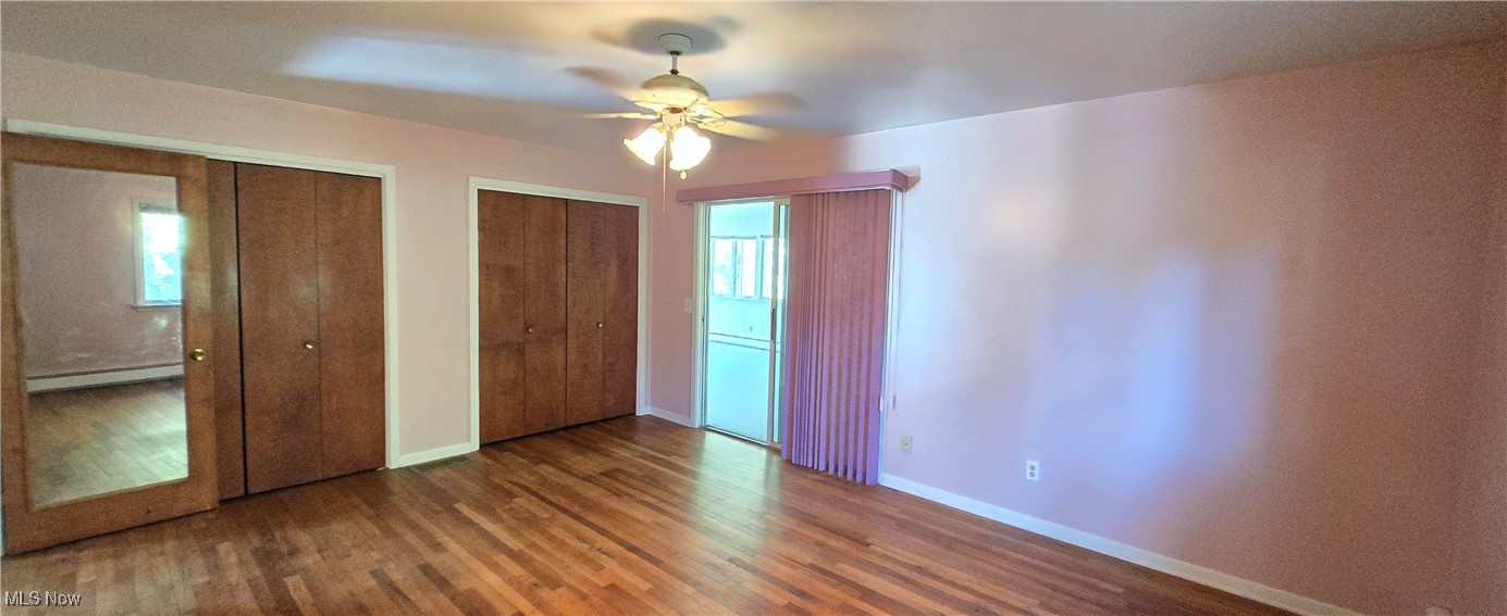 2707 Merriweather Road Sandusky, OH 44870 - Photo 22 of 28 Unfurnished bedroom with hardwood / wood-style flooring, two closets, ceiling fan, and a baseboard radiator