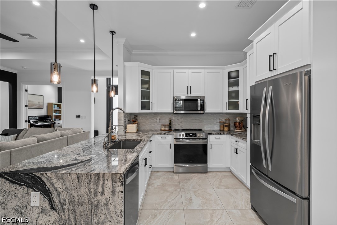 4498 8th Street Northeast Naples, FL 34120 - Photo 11 of 49 a kitchen with stainless steel appliances granite countertop a refrigerator a stove a sink and a oven