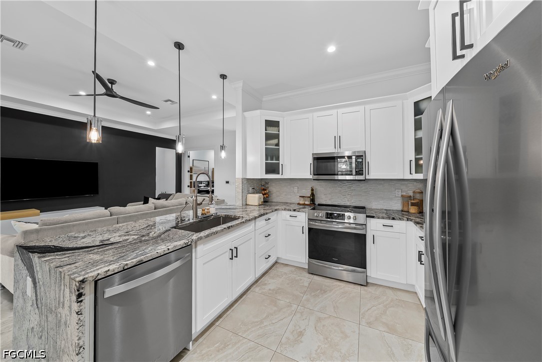 4498 8th Street Northeast Naples, FL 34120 - Photo 12 of 49 a kitchen with stainless steel appliances granite countertop a stove top oven a sink and a refrigerator