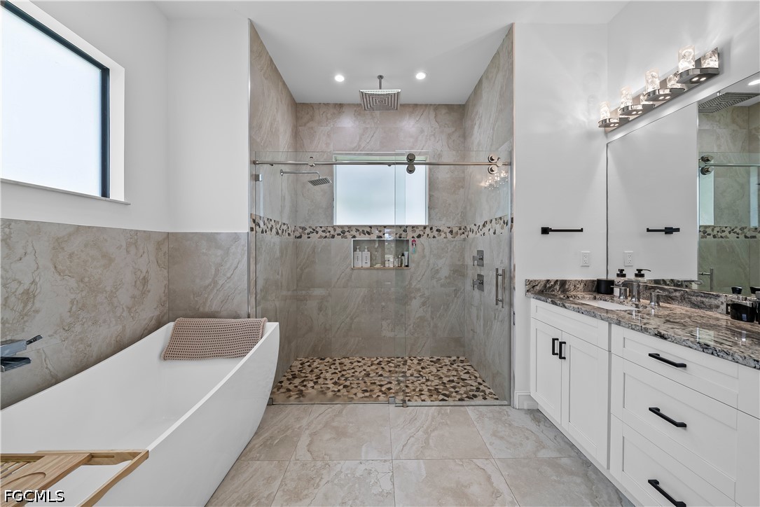 4498 8th Street Northeast Naples, FL 34120 - Photo 20 of 49 a bathroom with a granite countertop sink a toilet a mirror and shower