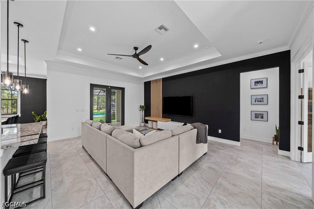 4498 8th Street Northeast Naples, FL 34120 - Photo 5 of 49 a living room with furniture a flat screen tv and a large window