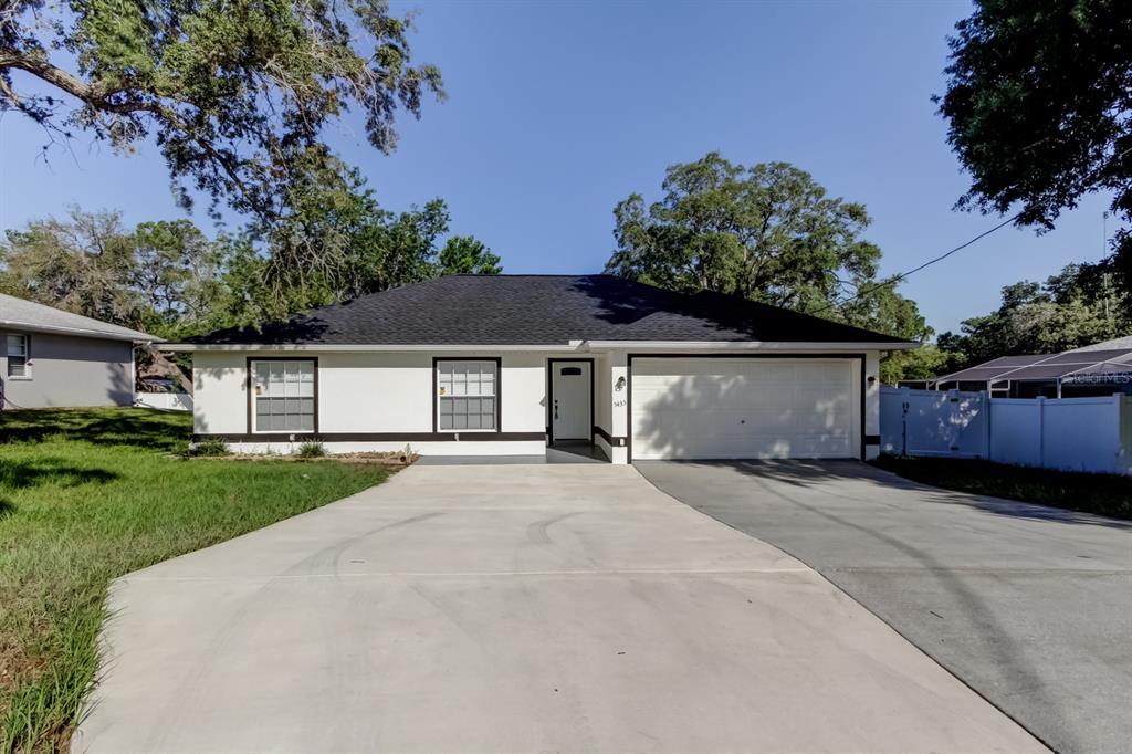 5435 Birchwood Road Spring Hill, FL 34608 - Photo 1 of 1 a front view of a house with a yard and garage