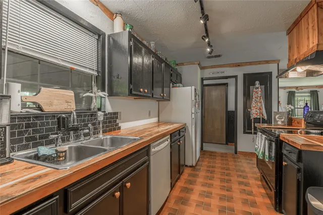a kitchen with stainless steel appliances a sink stove and cabinets